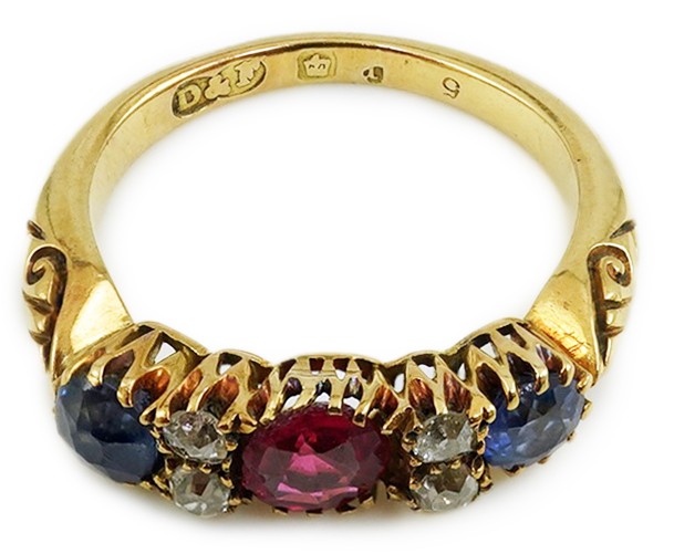 An early 20th century gold, ruby, sapphire and diamond cluster set half hoop ring